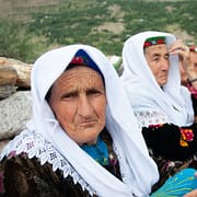 Photo by Joel Heard woman in white hijab sitting on green grass field