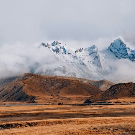 brown and white mountains under white clouds during daytime
