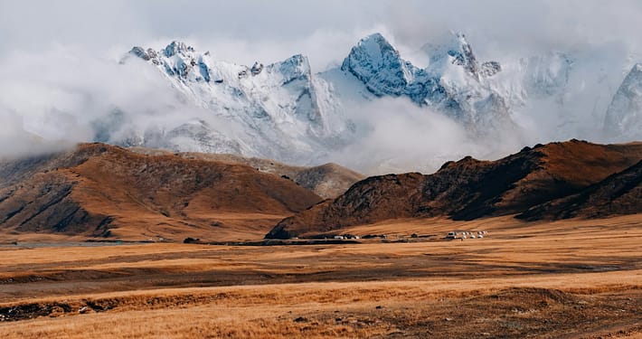 brown and white mountains under white clouds during daytime