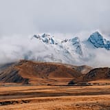 brown and white mountains under white clouds during daytime